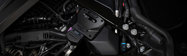 Boîtier RaceChip GTS 5 installé dans un compartiment moteur, connecteur d'origine branché.