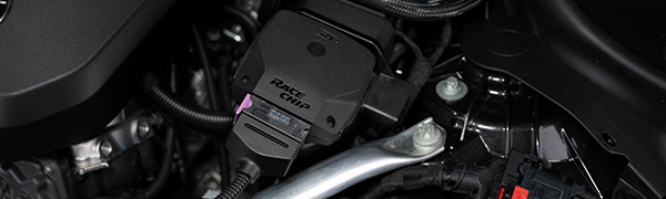 Boîtier RaceChip RS installé dans un compartiment moteur, connecteur d'origine branché.